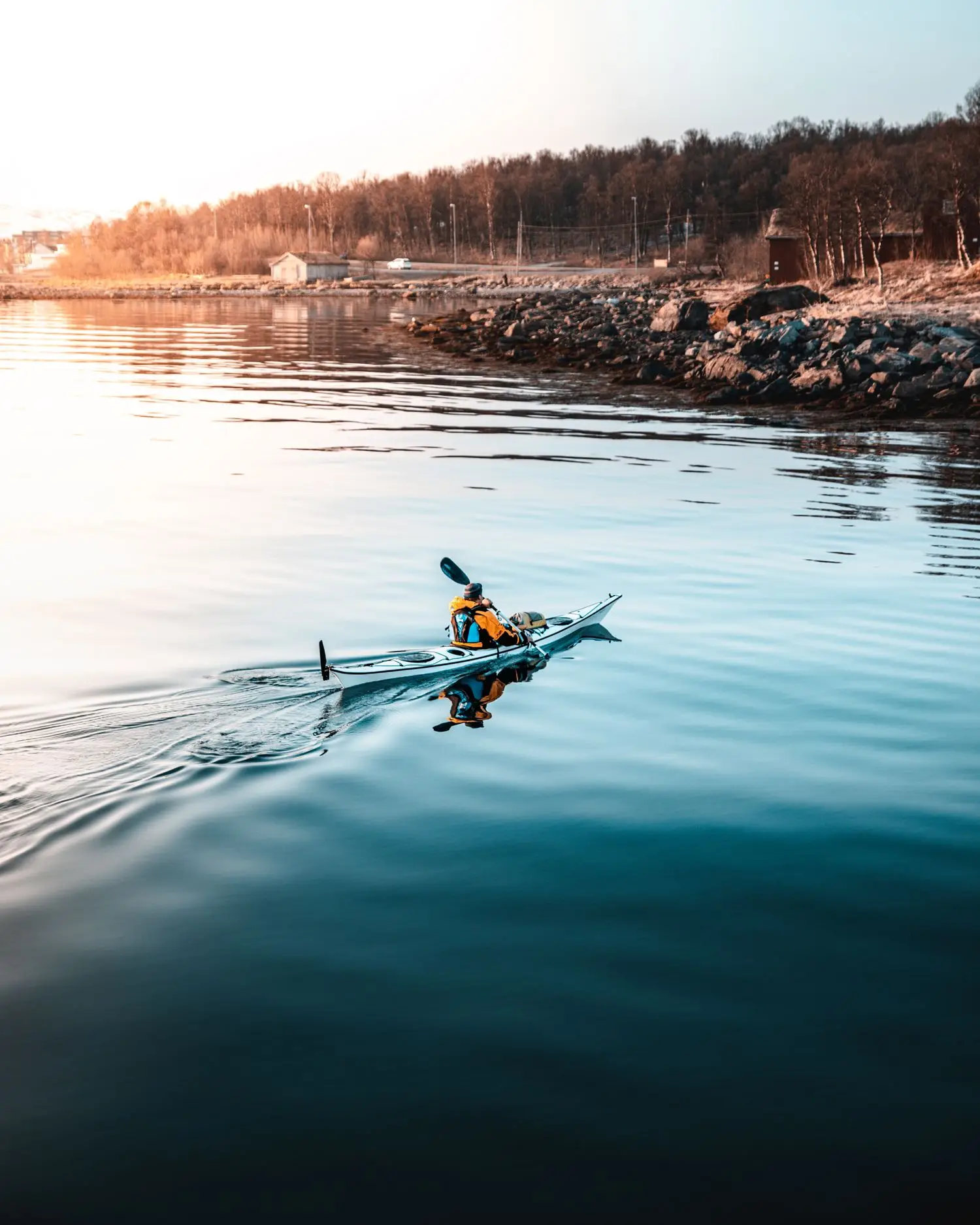 Single kayaker on reflective evening water